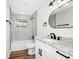 Modern bathroom featuring a granite countertop, tub and shower with marble tiles, and black hardware accents at 4710 Hatteras Ct, Orlando, FL 32808