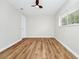 Bright bedroom with wood-look flooring, ceiling fan, window, and neutral paint at 4710 Hatteras Ct, Orlando, FL 32808