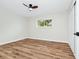 This bedroom boasts wood-look flooring, a ceiling fan, and a window providing natural light at 4710 Hatteras Ct, Orlando, FL 32808