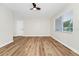 Bright living room with new wood floors, ceiling fan, freshly painted white walls, and large window at 4710 Hatteras Ct, Orlando, FL 32808