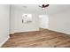 Inviting living room with a partial view into the kitchen, new wood floors, and freshly painted white walls at 4710 Hatteras Ct, Orlando, FL 32808
