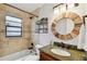 Stylish bathroom featuring a round mirror, granite counters, and a shower-tub combo at 1026 Manchester Cir, Winter Park, FL 32792