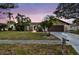 Charming single-story home featuring a well-manicured lawn and beautiful tropical landscaping at 1026 Manchester Cir, Winter Park, FL 32792