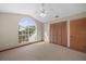 Light-filled bedroom featuring neutral carpet, arched window, and a closet with panel doors at 11160 Sylvan Pond Cir, Orlando, FL 32825