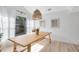 Sunlit dining area with a large table, pendant lighting, and picturesque window view at 1134 Shaffer Trl, Oviedo, FL 32765