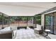 An enclosed patio features a checkered rug, glass windows and furniture, perfect for relaxing at 1134 Shaffer Trl, Oviedo, FL 32765