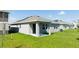 The backyard has a covered patio, green grass and simple landscaping at 1163 James Paul Rd, Davenport, FL 33837
