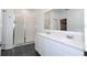 Bathroom with double sink vanity, frameless glass shower, and dark tile flooring at 1163 James Paul Rd, Davenport, FL 33837