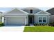 Charming single-story home with a well-maintained lawn, neutral paint, and an attached two-car garage at 1163 James Paul Rd, Davenport, FL 33837