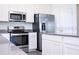 Bright kitchen featuring stainless steel appliances, white cabinets, and stylish countertops at 1163 James Paul Rd, Davenport, FL 33837