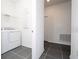 Laundry room features gray tiled floors and white appliances and shelving at 1163 James Paul Rd, Davenport, FL 33837