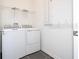 Bright laundry room with new, matching washer and dryer and wire shelving at 1163 James Paul Rd, Davenport, FL 33837