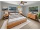 Bright bedroom featuring a wooden bed frame, neutral walls, tiled floors, and two windows providing natural light at 1249 12Th St, Clermont, FL 34711