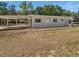 Back exterior view of the home featuring a covered patio and an air conditioning unit at 1249 12Th St, Clermont, FL 34711