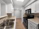 Well-lit kitchen featuring white cabinets, tile countertops, and modern appliances at 1249 12Th St, Clermont, FL 34711