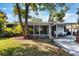 Exterior view of a backyard, featuring a patio, sunroom, and lush green space at 125 E Miller St, Orlando, FL 32806