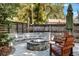 Charming backyard featuring a stone fire pit, built-in seating, and mature trees at 125 E Miller St, Orlando, FL 32806