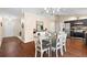 Bright dining room with a modern chandelier, glass table and matching white chairs at 131 Autumn Ct, St Cloud, FL 34771