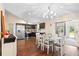 Bright kitchen with stainless steel appliances, dark cabinets, a chandelier and a glass table adjacent to the dining area at 131 Autumn Ct, St Cloud, FL 34771