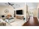 A well-lit living room featuring vaulted ceilings, a ceiling fan, a large TV and stylish decor at 131 Autumn Ct, St Cloud, FL 34771