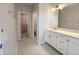Well-lit bathroom features a modern vanity with white cabinets and a view into the walk-in closet at 1360 Twelve Oaks Rd, St Cloud, FL 34771
