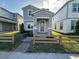 Well-manicured lawn and inviting covered entry of gray two-story home with stone accents at 1360 Twelve Oaks Rd, St Cloud, FL 34771