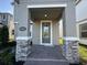 Charming front porch with brick pillars, patterned pavers, and a gray door at 1360 Twelve Oaks Rd, St Cloud, FL 34771