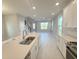 Open-concept kitchen with a view of the living area, featuring an island, stainless steel appliances, and ample lighting at 1360 Twelve Oaks Rd, St Cloud, FL 34771