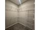 Walk-in closet with carpet floor, white wire shelving, and ample vertical space for organized storage at 1360 Twelve Oaks Rd, St Cloud, FL 34771