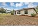 View of the home's backyard, complete with a sliding glass door and partial grass coverage at 14066 Sw 60Th Ter, Ocala, FL 34473