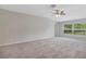This large bedroom has new carpet, neutral paint, a ceiling fan and a window at 14066 Sw 60Th Ter, Ocala, FL 34473