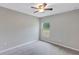 This carpeted bedroom has a ceiling fan and a window letting in natural light at 14066 Sw 60Th Ter, Ocala, FL 34473
