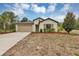 Charming single-story home with a well-manicured front lawn, attached garage, and neutral color palette at 14066 Sw 60Th Ter, Ocala, FL 34473