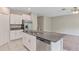 Modern kitchen with granite island, stainless steel appliances, and white cabinetry, seamlessly flowing into living area at 14066 Sw 60Th Ter, Ocala, FL 34473