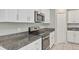 Sleek kitchen featuring stainless steel appliances, stylish range hood, granite counters and ample cabinet storage at 14066 Sw 60Th Ter, Ocala, FL 34473
