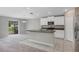 Open-concept kitchen with granite island, white cabinetry, stainless appliances, and seamless flow to carpeted living space at 14066 Sw 60Th Ter, Ocala, FL 34473