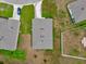 Aerial view of a home with a gray roof, green grass, and other homes nearby at 149 Hickory Course Cir, Ocala, FL 34472