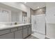 Bathroom featuring a double sink vanity with marbled countertops and a walk-in shower at 149 Hickory Course Cir, Ocala, FL 34472