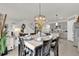 Dining area features modern chandelier, decor, and views into the kitchen and living spaces at 149 Hickory Course Cir, Ocala, FL 34472