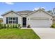 Charming single-story home with a well-manicured lawn, blue shutters, and a two-car garage at 149 Hickory Course Cir, Ocala, FL 34472