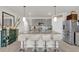 Bright kitchen featuring a large island with barstools, pendant lighting and gray cabinetry at 149 Hickory Course Cir, Ocala, FL 34472