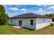 Exterior rear view of home with sliding glass door leading to concrete pad and grassy yard at 15296 Sw 56Th Terrace Rd, Ocala, FL 34473