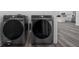 Modern laundry room features Samsung washer and dryer on wood-look flooring, with a glimpse of the kitchen at 15296 Sw 56Th Terrace Rd, Ocala, FL 34473