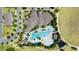 Aerial view of a stunning community pool area surrounded by lush greenery and lounge chairs at 16137 Azure Key St, Winter Garden, FL 34787