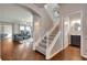 Open entryway with hardwood floors, a carpeted staircase, and a view of the living room and powder room at 16137 Azure Key St, Winter Garden, FL 34787