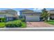 Charming home exterior with a brick driveway, a two-car garage, and green landscaping at 16137 Azure Key St, Winter Garden, FL 34787