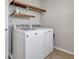 Well-equipped laundry room with modern washer and dryer units, plus storage shelving at 16137 Azure Key St, Winter Garden, FL 34787