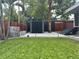 Landscaped backyard featuring a modern shed, stone patio, and lush green grass, perfect for outdoor enjoyment at 1634 Hull Cir, Orlando, FL 32806