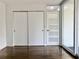 Bedroom with sliding closet doors, white walls, and hardwood floors at 1634 Hull Cir, Orlando, FL 32806