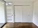 Bedroom with sliding closet doors, white walls, hardwood floors, and patio access at 1634 Hull Cir, Orlando, FL 32806